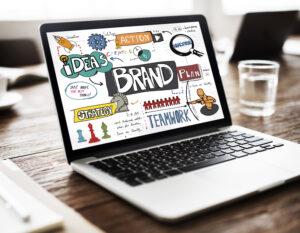 Open laptop over table displaying branding related words