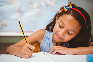 Little girl writing and smiling